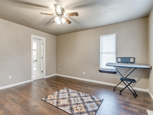 interior space with baseboards, a textured ceiling, wood finished floors, and a ceiling fan