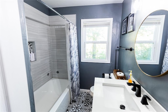 full bathroom with tile patterned floors, shower / bath combo with shower curtain, sink, and toilet