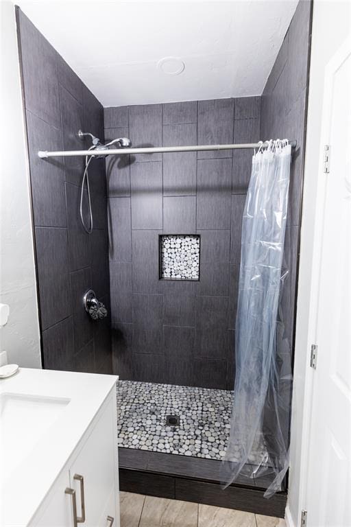 bathroom with curtained shower, tile patterned flooring, and vanity