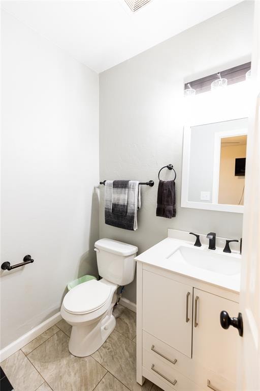 bathroom featuring tile patterned flooring, vanity, and toilet