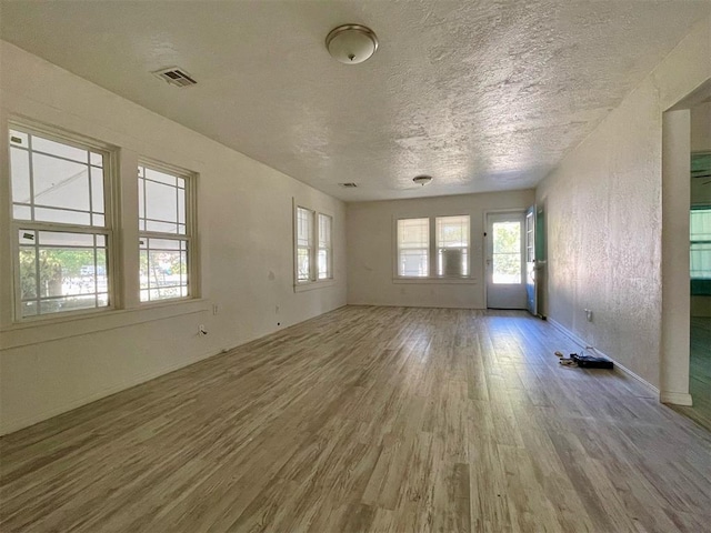 empty room with a textured ceiling and hardwood / wood-style flooring