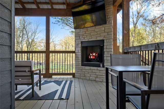 wooden deck with an outdoor stone fireplace