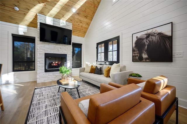 living room featuring wood-type flooring, a fireplace, high vaulted ceiling, and wooden ceiling