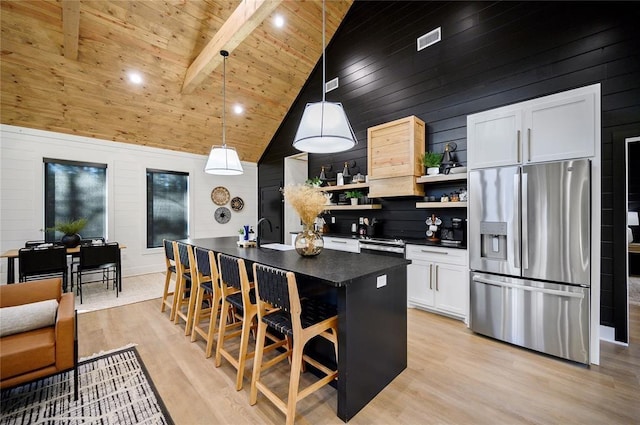 kitchen featuring beamed ceiling, high vaulted ceiling, stainless steel refrigerator with ice dispenser, decorative light fixtures, and white cabinets