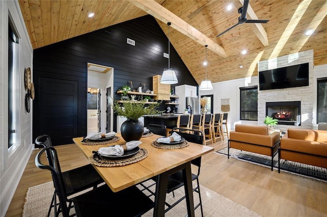 dining space with beamed ceiling, light hardwood / wood-style floors, ceiling fan, and wood ceiling