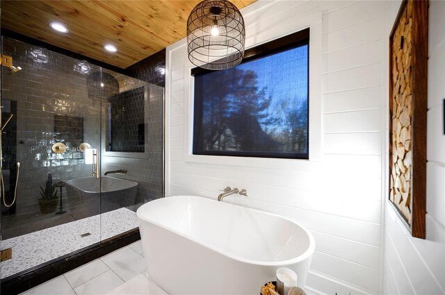 bathroom with tile patterned floors and independent shower and bath