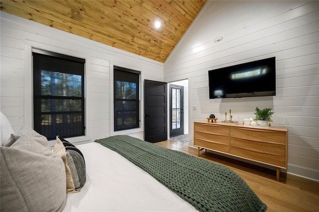 bedroom featuring wooden walls, hardwood / wood-style floors, high vaulted ceiling, and wooden ceiling