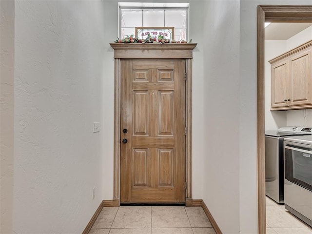 doorway to outside featuring washer and dryer and light tile patterned floors