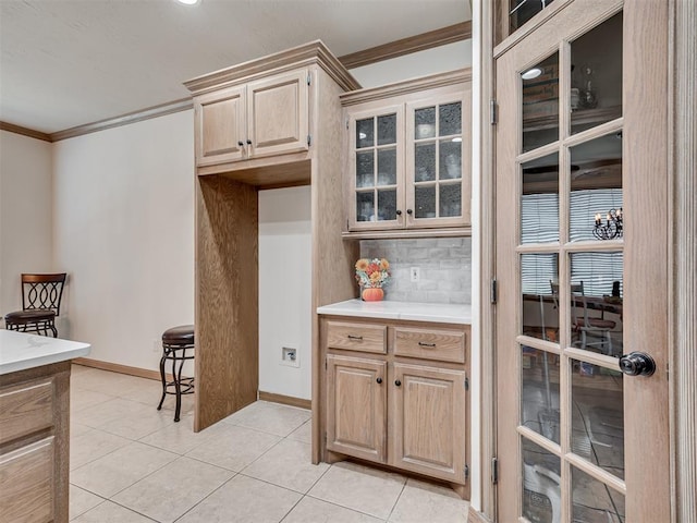 kitchen with backsplash, crown molding, light brown cabinetry, and light tile patterned floors