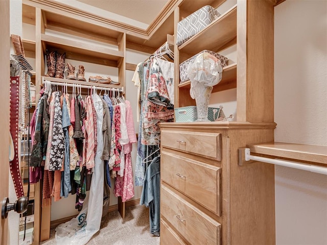 walk in closet featuring light carpet