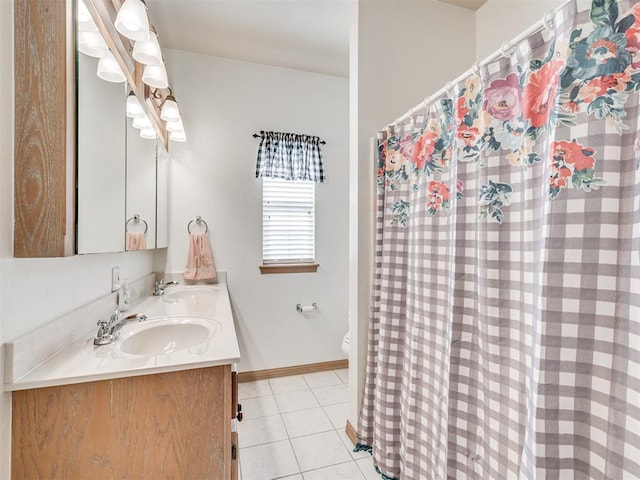 bathroom with toilet, vanity, and tile patterned floors