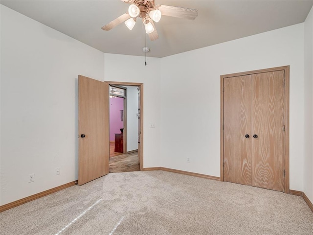 unfurnished bedroom with ceiling fan, light colored carpet, and a closet