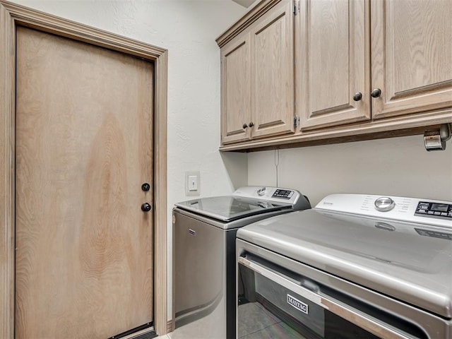 clothes washing area with cabinets, washing machine and dryer, and tile patterned flooring