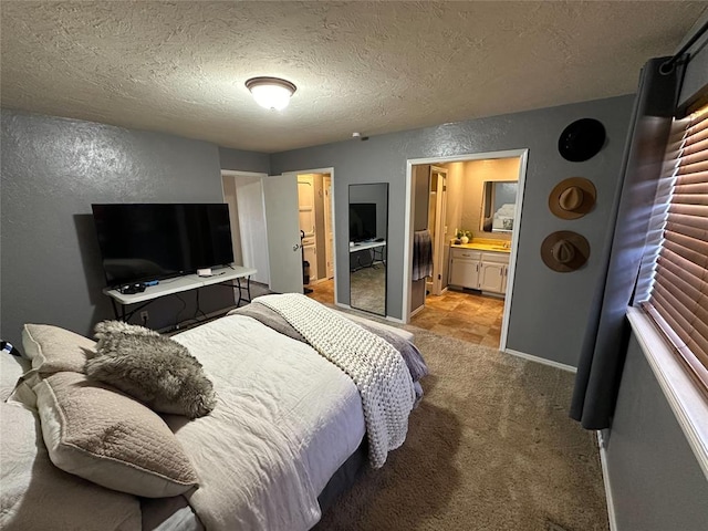 carpeted bedroom featuring a textured ceiling and ensuite bathroom