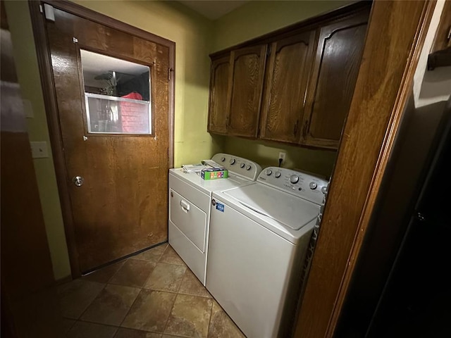 laundry room with washer and clothes dryer, cabinets, and light tile patterned floors