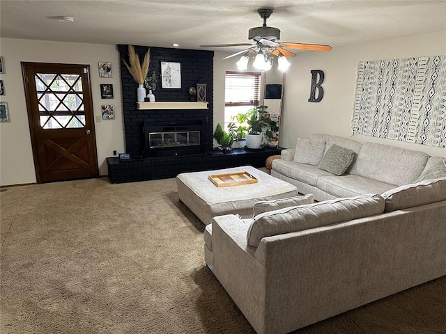 carpeted living room featuring a textured ceiling, ceiling fan, and a fireplace