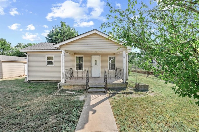 bungalow-style house featuring covered porch and a front yard