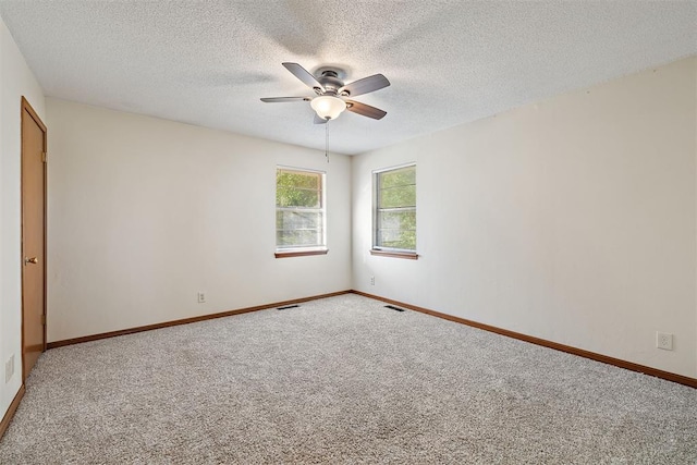 spare room featuring a textured ceiling, carpet floors, and ceiling fan