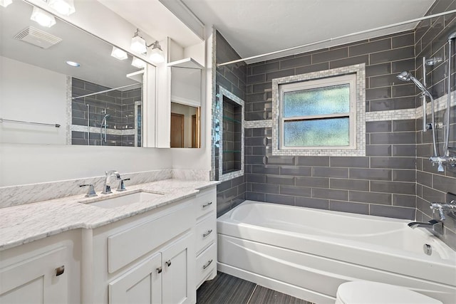 full bathroom featuring vanity, toilet, and tiled shower / bath combo