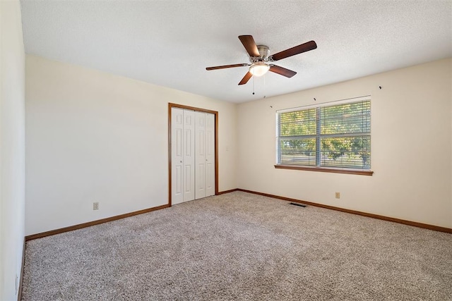 unfurnished bedroom with carpet flooring, ceiling fan, and a closet