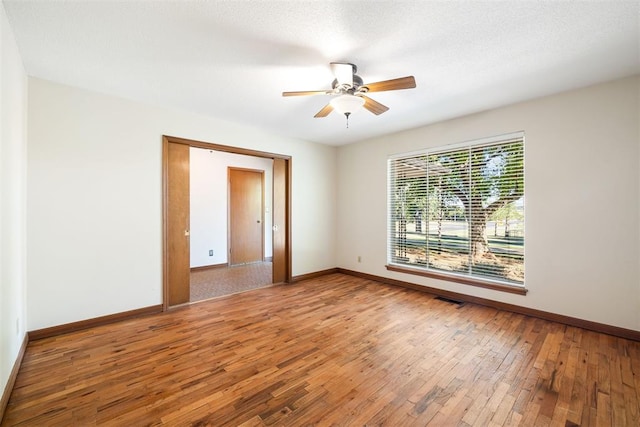 spare room featuring hardwood / wood-style floors, ceiling fan, and a textured ceiling