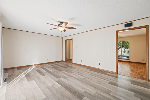 unfurnished room featuring ceiling fan, ornamental molding, a textured ceiling, and light hardwood / wood-style flooring