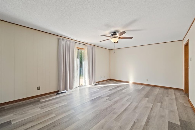 spare room featuring a textured ceiling, ceiling fan, light wood-type flooring, and ornamental molding