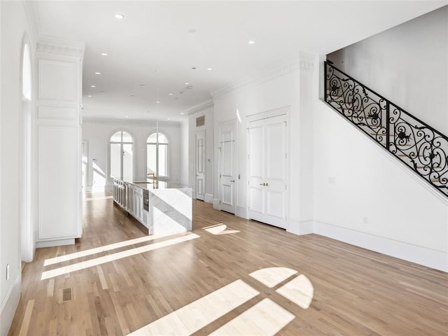 interior space with light hardwood / wood-style floors and ornamental molding