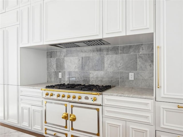 kitchen with decorative backsplash, white cabinetry, light stone countertops, and high end white range oven