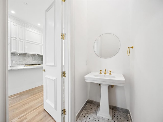 bathroom featuring decorative backsplash and wood-type flooring