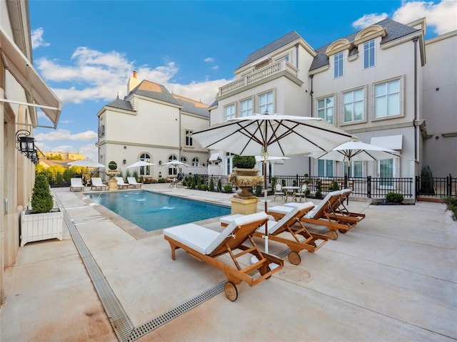 view of swimming pool with pool water feature and a patio area