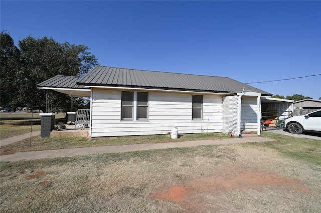 view of property exterior with a carport and a lawn