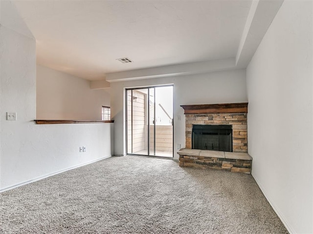 unfurnished living room featuring carpet flooring and a stone fireplace