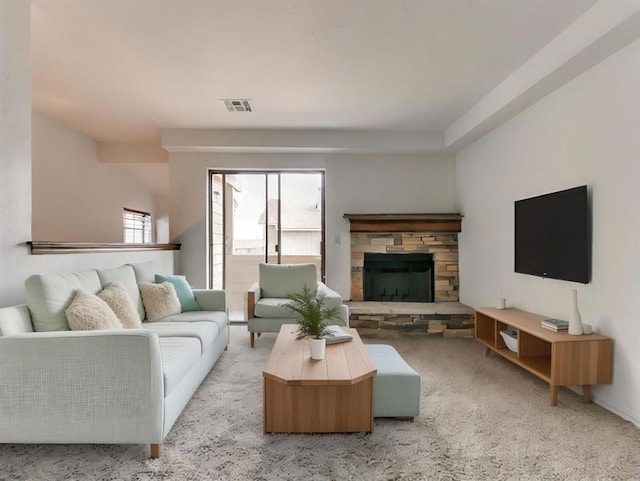 living room featuring a healthy amount of sunlight, light colored carpet, and a fireplace