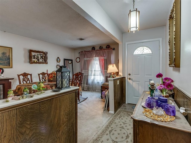 carpeted entryway featuring a textured ceiling and plenty of natural light