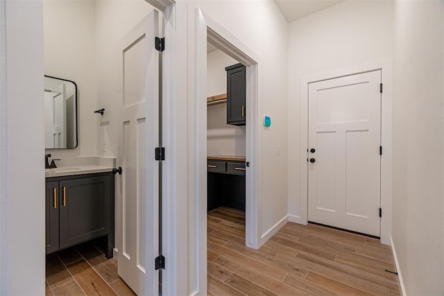 11601 SW 58th St, Mustang, OK 73064 - corridor with light wood-style flooring, baseboards, and a sink