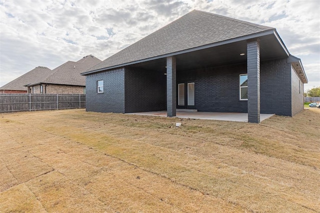 11601 SW 58th St, Mustang, OK 73064 - back of house featuring a patio, brick siding, and roof with shingles