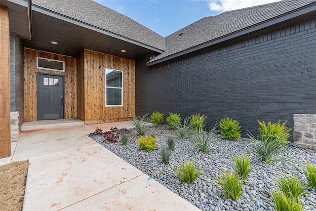 11601 SW 58th St, Mustang, OK 73064 - doorway to property featuring roof with shingles and brick siding