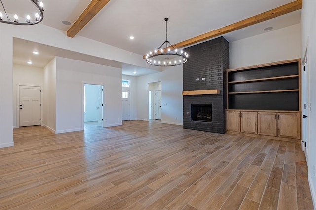 11601 SW 58th St, Mustang, OK 73064 - unfurnished living room with a chandelier, beam ceiling, light wood-style flooring, a fireplace, and baseboards