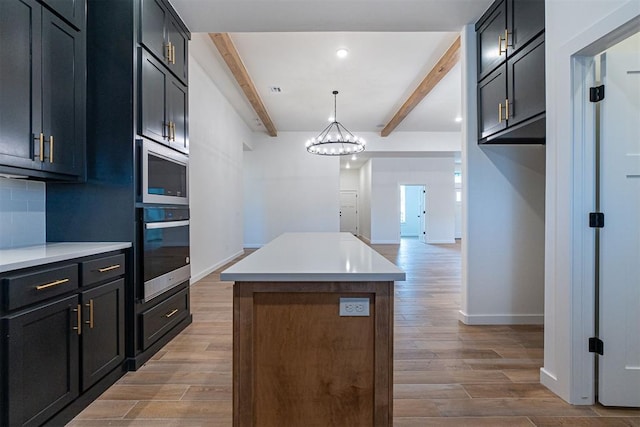 11601 SW 58th St, Mustang, OK 73064 - kitchen with appliances with stainless steel finishes, beam ceiling, light wood-type flooring, a kitchen island, and light countertops
