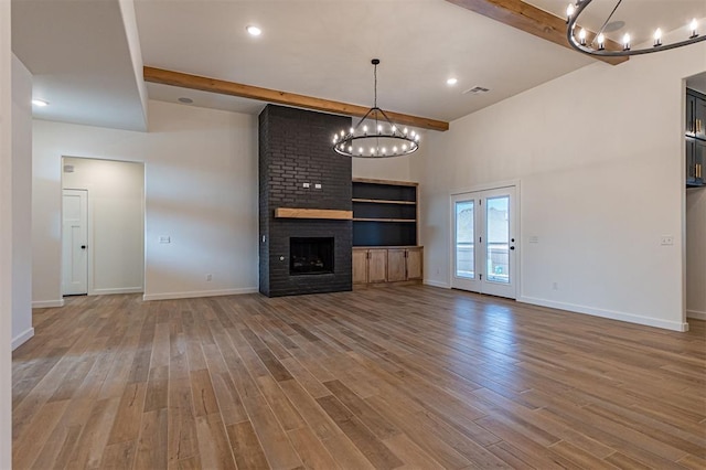 11601 SW 58th St, Mustang, OK 73064 - unfurnished living room with beam ceiling, a chandelier, light wood-style floors, baseboards, and a fireplace