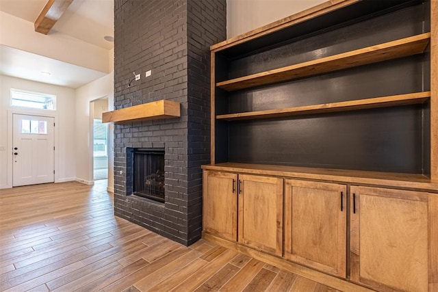 11601 SW 58th St, Mustang, OK 73064 - unfurnished living room featuring light wood-style flooring and a brick fireplace