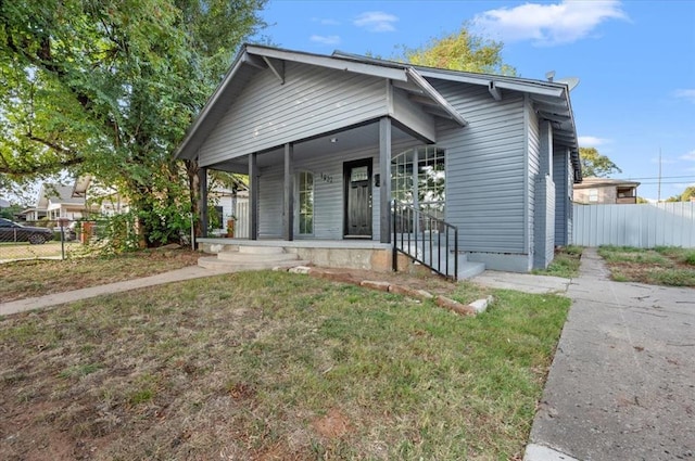 bungalow with covered porch and a front yard