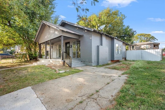 exterior space featuring covered porch and a front lawn