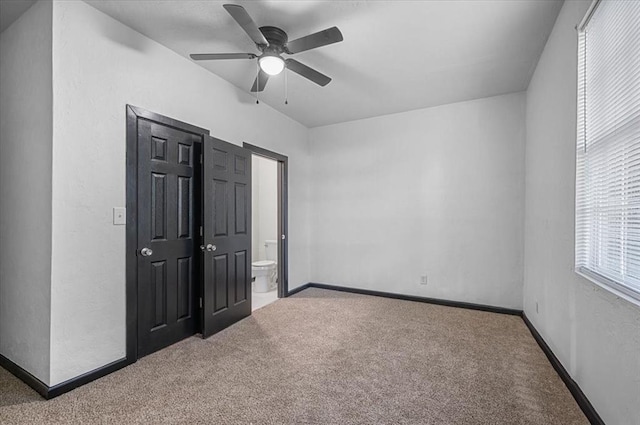 unfurnished bedroom with carpet flooring, connected bathroom, and ceiling fan