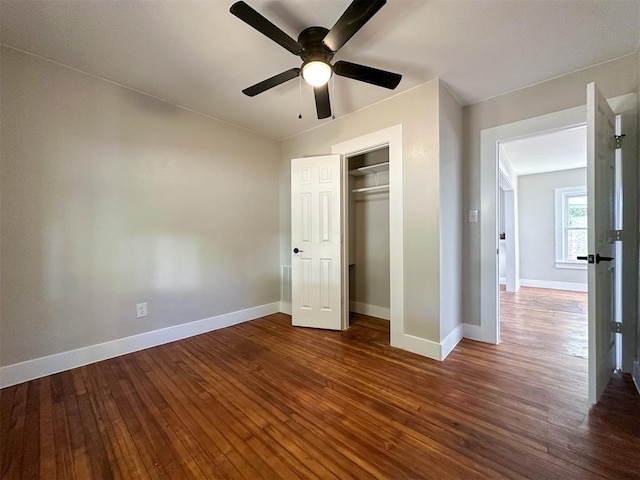 unfurnished bedroom with ceiling fan, a closet, and hardwood / wood-style flooring