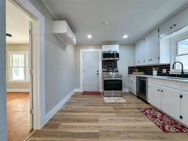 kitchen with sink, white cabinets, a healthy amount of sunlight, and appliances with stainless steel finishes