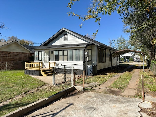 rear view of house featuring a carport and a yard