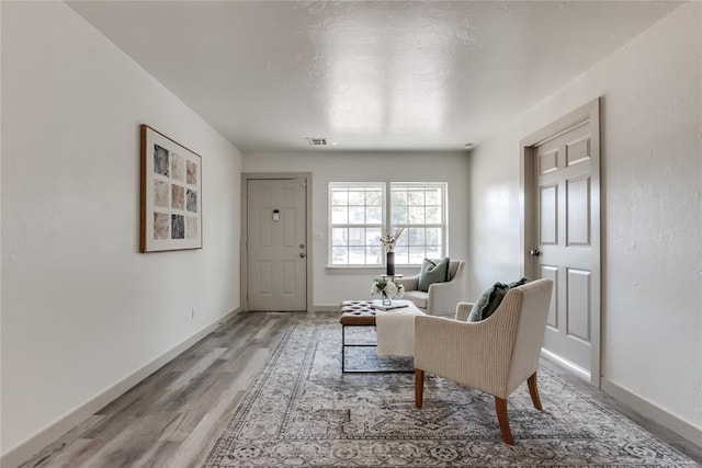 sitting room with wood-type flooring