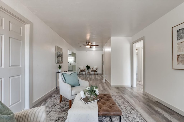 living area featuring light wood-type flooring and ceiling fan